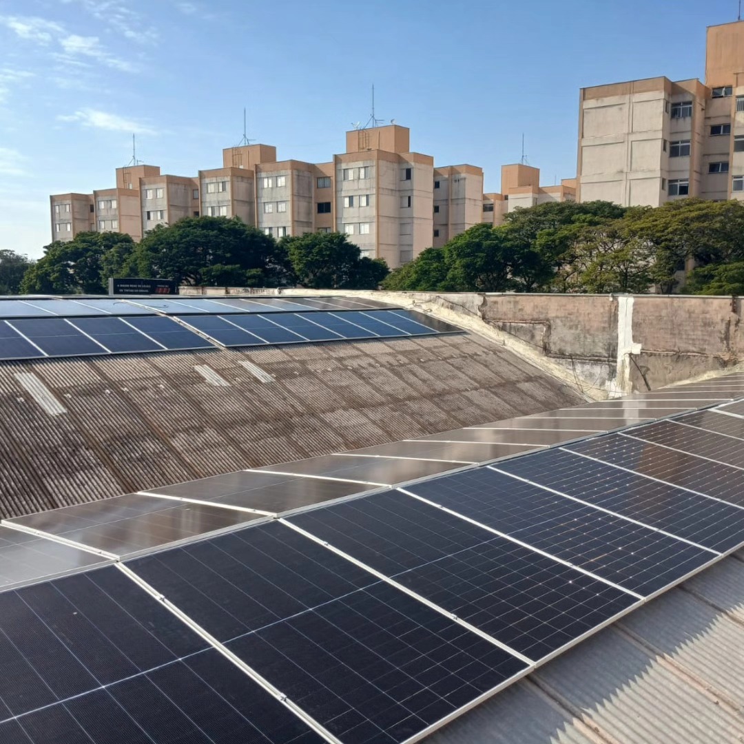Sistema fotovoltaico em laje de edifício residencial com prédios ao fundo
